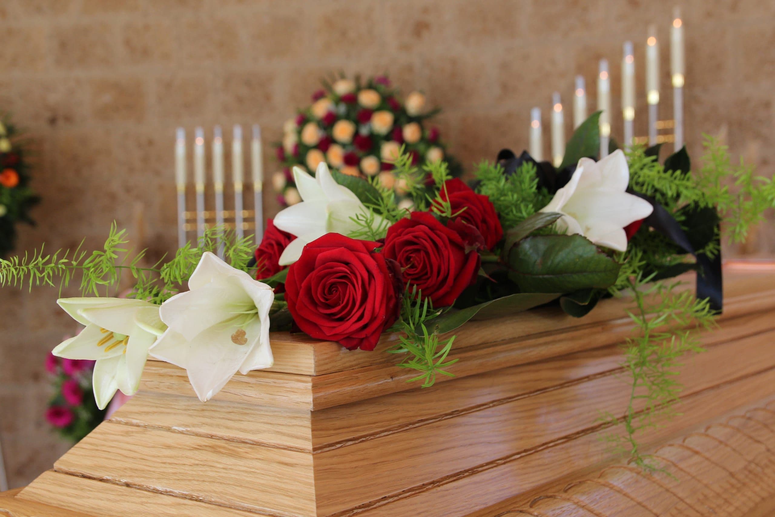 Holzsarg mit Rosen und Lilien