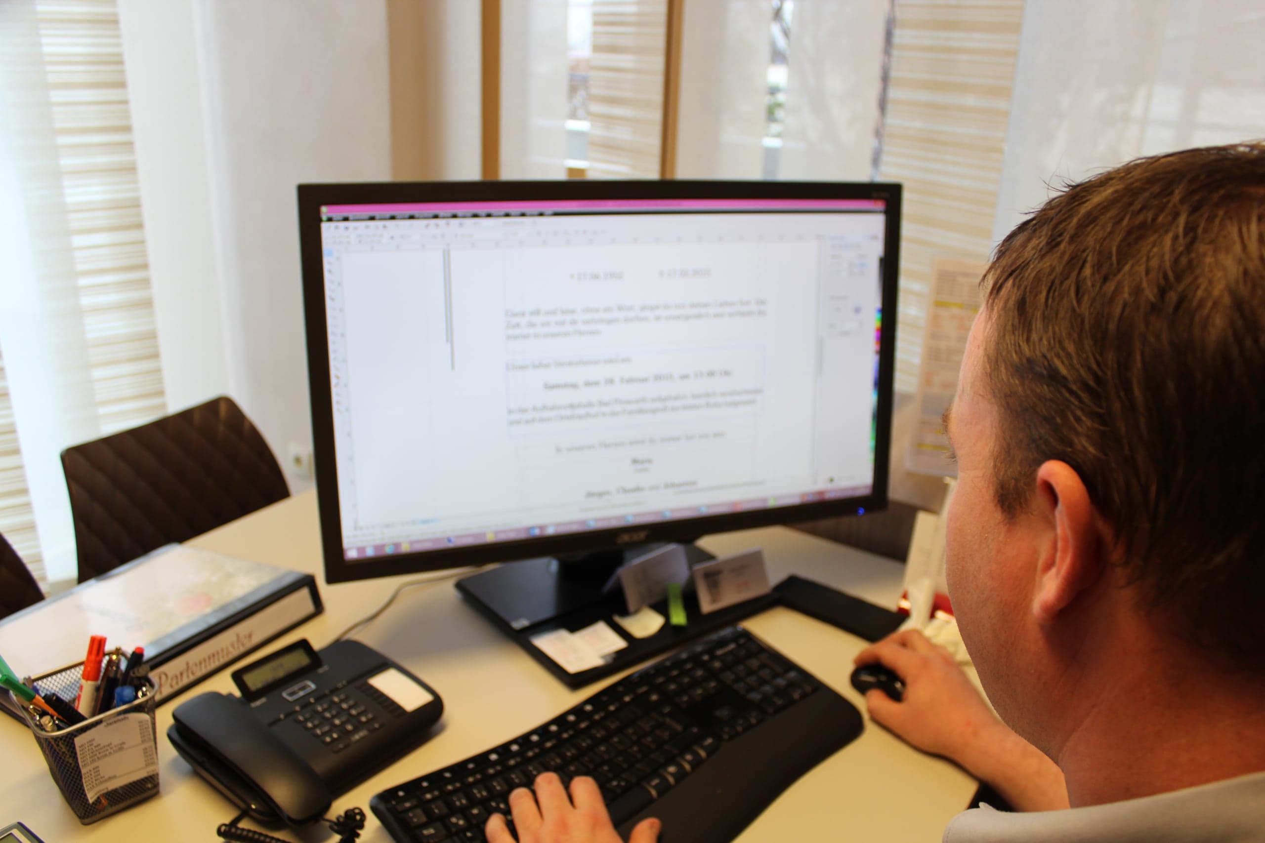 Mitarbeiter der Bestattung Pernold bei der Organisation am Schreibtisch
